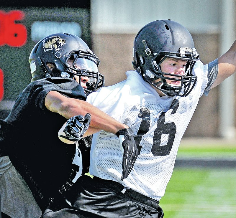  STAFF PHOTO BEN GOFF &#8226; @NWABenGoff Tyrone Mahone, left, defensive back, forces receiver Bradley Burke out of bounds during the first day of practice at Tiger Stadium in Bentonville on Monday.