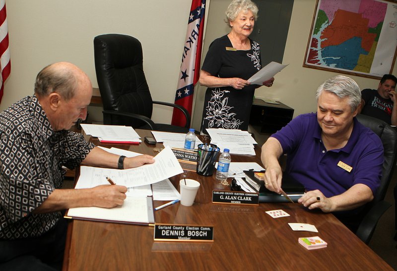 The Sentinel-Record/Richard Rasmussen BALLOT POSITIONS: Garland County Election Commission members Dennis Bosch, left, Ginna Watson and Alan Clark conduct the draw for postions on the November ballot on Friday.