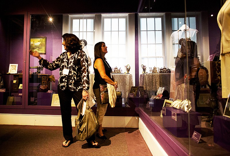 Arkansas Democrat-Gazette/Melissa Sue Gerrits ON DISPLAY: Brenda Parker, left, and Claudia Moran look at dresses on display at the Old State House Museum in the First Ladies’ gown collection on Friday. The collection includes inaugural gowns representing 120 years of Arkansas history.