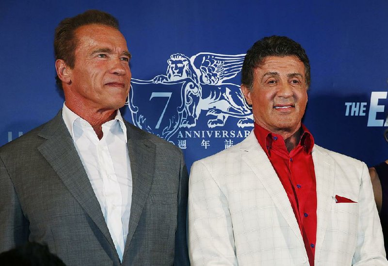 U.S. actors, Arnold Schwarzenegger, left, and Sylvester Stallone, pose on the red carpet for the Macau premiere of their movie "The Expendables 3" in Macau, China, Friday, Aug. 22, 2014. (AP Photo/Kin Cheung)