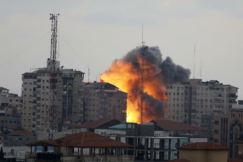 A ball of fire rises from an explosion on al-Zafer apartment  tower following an Israeli airstrikes in Gaza City, in the northern Gaza Strip, Saturday, Aug. 23, 2014. Israeli aircraft fired two missiles at a 12-story apartment tower in downtown Gaza City on Saturday, collapsing the building, sending a huge fireball into the sky and wounding at least 22 people, including 11 children, witnesses and Palestinian officials said. (AP Photo/Adel Hana)