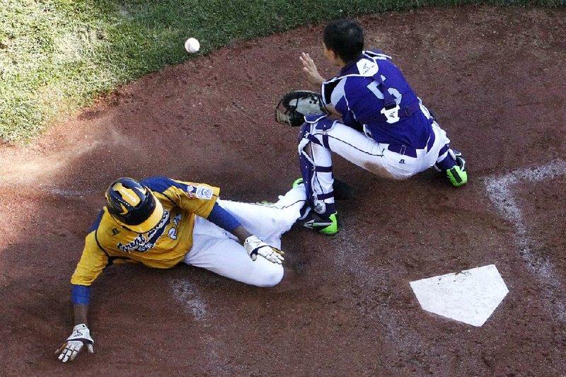 Chicago's Trey Hondras, left, scores ahead of the throw to South Korea catcher Sang Hoon Han (5) in the sixth inning of the Little League World Series championship baseball game in South Williamsport, Pa., Sunday, Aug. 24, 2014. South Korea won 8-4.  (AP Photo/Gene J. Puskar)