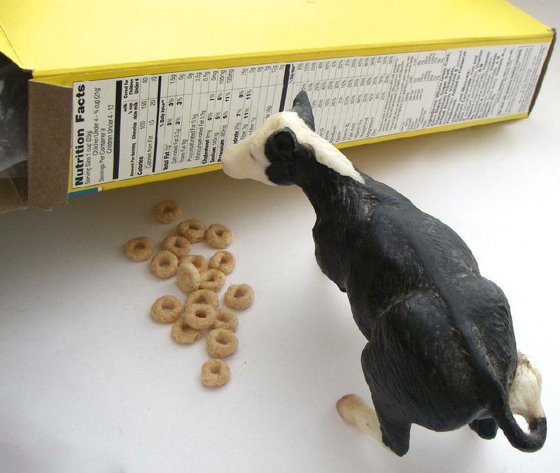 Arkansas Democrat-Gazette photo illustration/CELIA STOREY
Cow reading nutrition facts label on a box of cereal, to illustrate wire story about protein-added products fad.