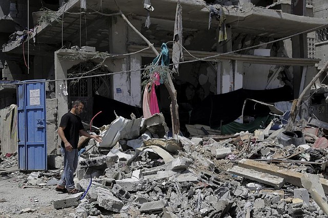 A Palestinian inspects the rubble of a damaged building after an Israeli strike in Gaza City in the northern Gaza Strip, Sunday, Aug. 24, 2014. (AP Photo/Adel Hana)