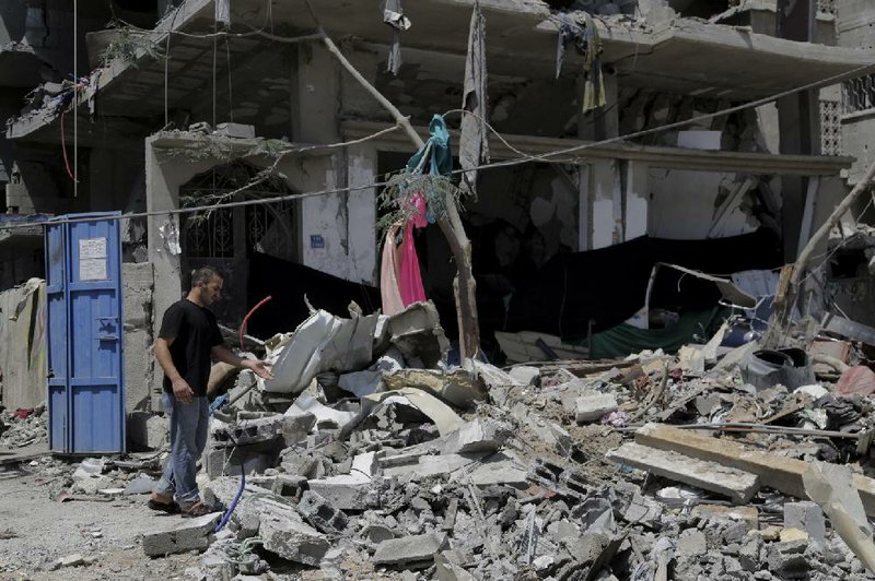 A Palestinian inspects the rubble of a damaged building after an Israeli strike in Gaza City in the northern Gaza Strip, Sunday, Aug. 24, 2014. (AP Photo/Adel Hana)