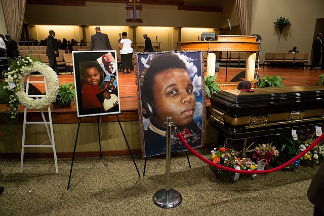 Photos surround the casket of Michael Brown before the start of his funeral at Friendly Temple Missionary Baptist Church in St. Louis, Monday, Aug. 25, 2014. Brown, who is black, was unarmed when he was shot Aug. 9 in Ferguson, Mo., by Officer Darren Wilson, who is white. Protesters took to the streets of the St. Louis suburb night after night, calling for change and drawing national attention to issues surrounding race and policing.