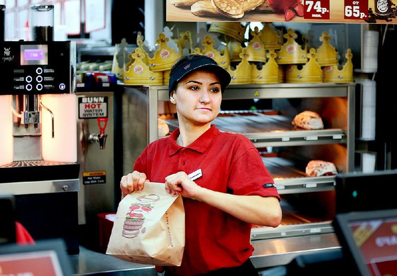 An employee prepares a bag containing a customer's food order inside a Burger King fast food restaurant in Moscow, Russia, on Friday, April 5, 2013. McDonald's, which virtually created the market for burgers and fries in the country and convinced Russians it's OK to eat with their hands, must fend off a growing challenge from rivals Burger King Worldwide Inc., Subway Restaurants, Yum! Brands Inc. and Wendy's Co. Photographer: Andrey Rudakov/Bloomberg