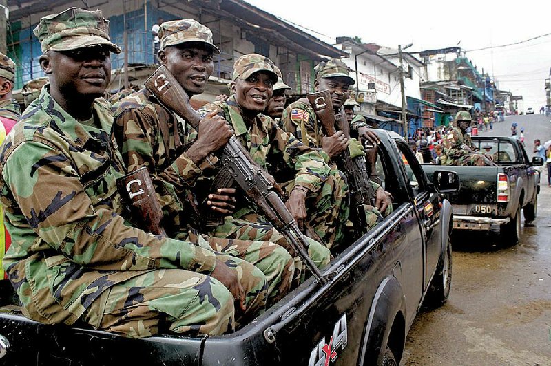 Liberian security forces patrol the entrance to West Point that has been hardest hit by the Ebola virus spreading in Monrovia, Liberia, Monday, Aug. 25, 2014.  A Liberian doctor who was among three Africans to receive an experimental Ebola drug has died, the country's information minister said Monday.(AP Photo/Abbas Dulleh)