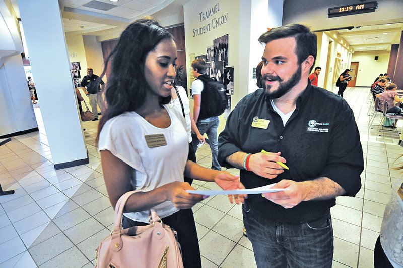 STAFF PHOTO J.T. Wampler D.J. Cameron, right, a student ambassador at NorthWest Arkansas Community College in Bentonville, helps Jasmine Joyner with directions Monday as the student center bustles with activity. Monday was the first day of class at the college in Bentonville.