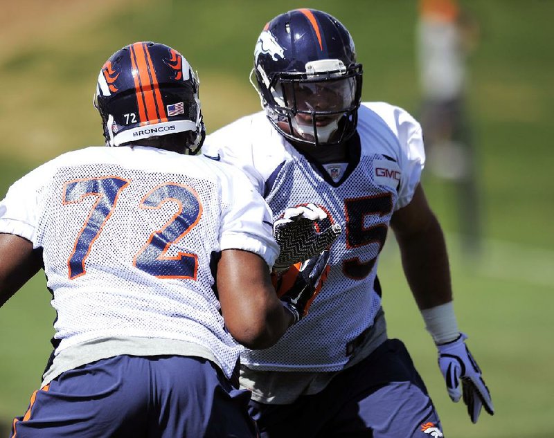 Denver Broncos defensive end Brian Sanford, left, and Denver Broncos defensive end Derek Wolfe, right, run a drill at NFL football practice in Englewood, Colo., on Monday, Aug. 25, 2014. (AP Photo/Chris Schneider)