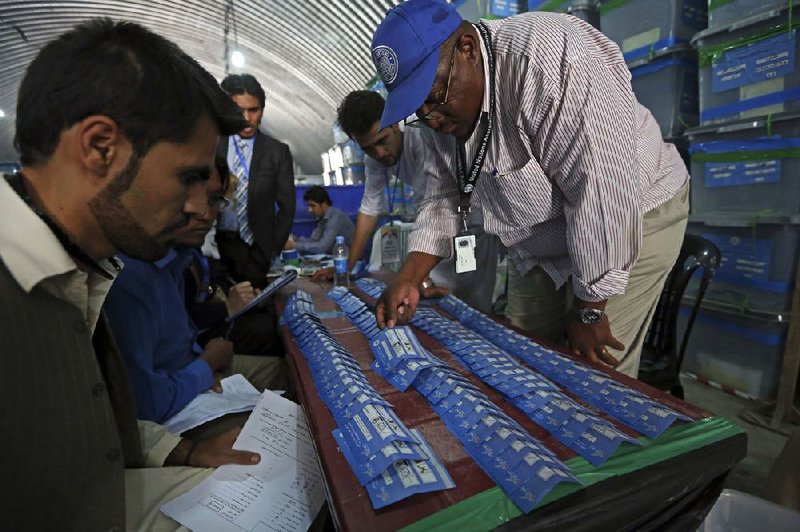 Afghan election commission workers sort ballots for an audit of the presidential run-off votes at an election commission office in Kabul, Afghanistan, Monday, Aug. 25, 2014. Afghanistan's president Hamid Karzai said in a statement that the inauguration ceremony for the next country's president will be held on September 2, 2014 and it is not subject to change. (AP Photo/Rahmat Gul)
