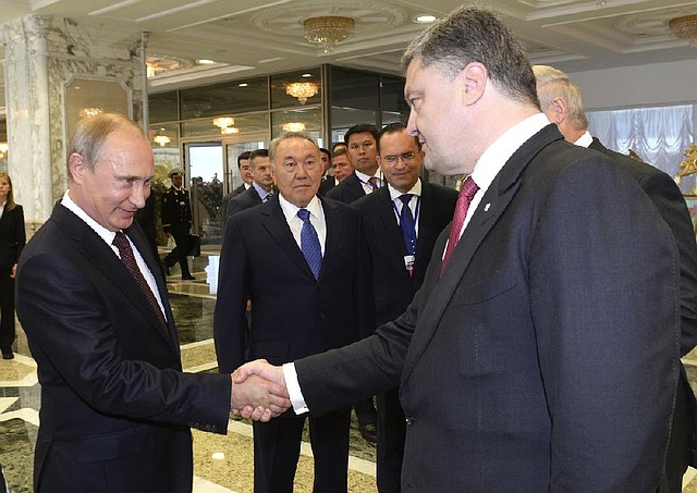 Russian President Vladimir Putin (left) and Ukrainian President Petro Poroshenko greet each other Tuesday before the start of their talks in Minsk, Belarus. Behind them is Kazakh President Nursultan Nazarbayev.