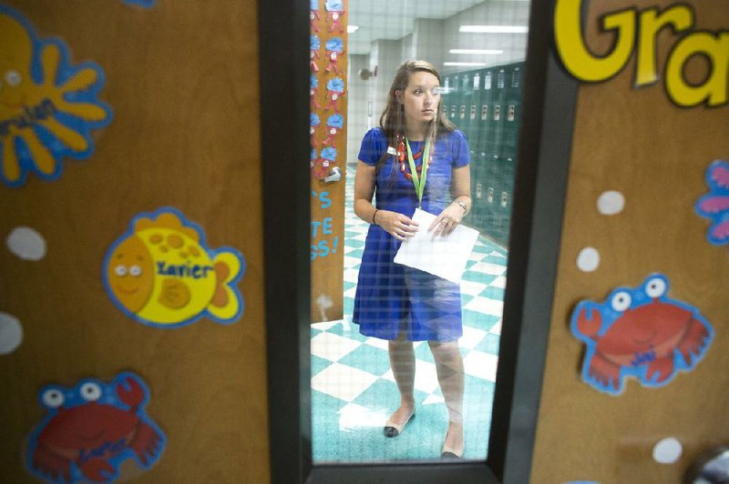 Beyond a classroom door at Forest Heights STEM Academy, Laura Hope and other (unseen) teachers meet in the hall Aug. 18 to plan how to organize the procession of pupils to their buses and waiting cars once school’s out.