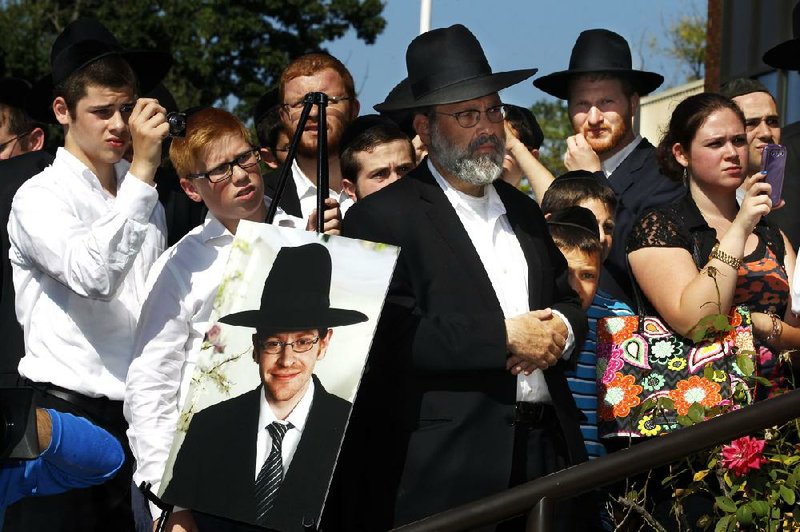 A photograph of Aaron Sofer, 23, is nearby as people listen during a news conference Tuesday, Aug. 26, 2014, in Lakewood, N.J. Israeli police said Tuesday they are searching for the young New Jersey religious student who went missing during a hike in a forest outside Jerusalem last week. Sofer of Lakewood, New Jersey, has been missing since Friday when he went on a hike with a friend in the Jerusalem Forest, said police spokesman Micky Rosenfeld. Rosenfeld said that police have launched an extensive search for Sofer, who is an ultra-Orthodox student at a yeshiva — a Jewish religious school. Sofer's parents have flown to Israel. (AP Photo/Mel Evans)