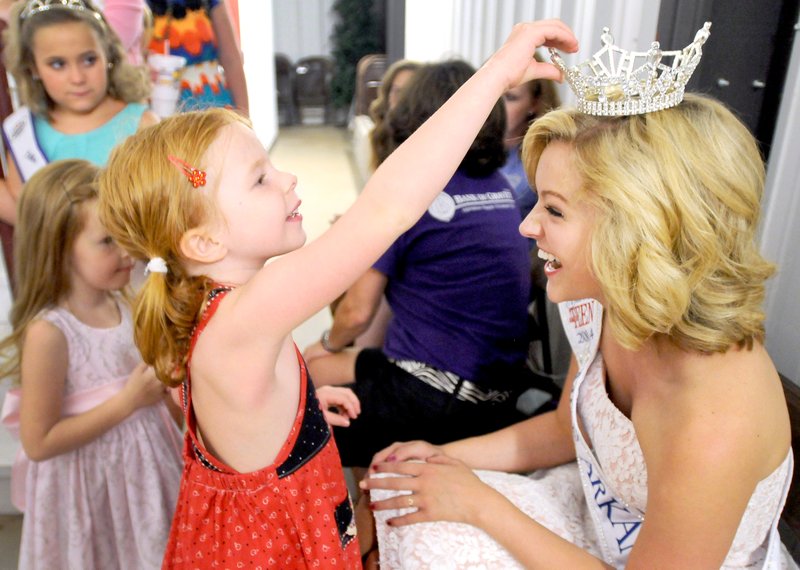 Photo by Ben Goff Emily Horton, 5, of Bentonville, feels the crown of Ashton Yarbrough, 17, of Gravette, 2014 Miss Arkansas Outstanding Teen, as Yarbrough greets participants in the tiny tot age group during the Tiny and Little Miss Benton County pageant at the Benton County Fair near Bentonville on Saturday, Aug. 16.
