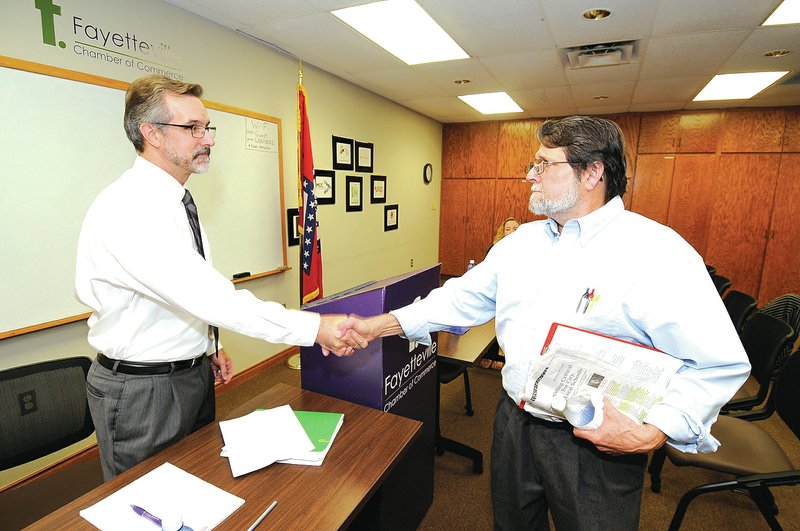 STAFF PHOTO J.T. Wampler Tim Hudson, left, and Tim Hollis, both Fayetteville School Board candidates, shake hands Tuesday before a forum hosted by the Fayetteville Chamber of Commerce. Hudson is the incumbent in the race.