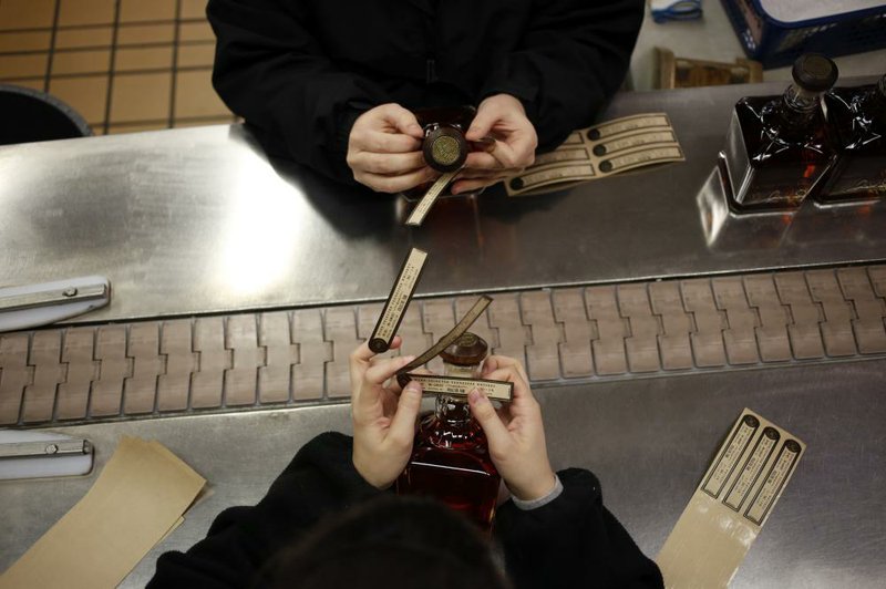 Workers attach labels to bottles of Jack Daniel’s Single Barrel Select Tennessee Whiskey at the Jack Daniel’s Distillery in Lynchburg, Tenn. Jack Daniel’s owner Brown-Forman said Wednesday that its first-quarter net income rose 5 percent.