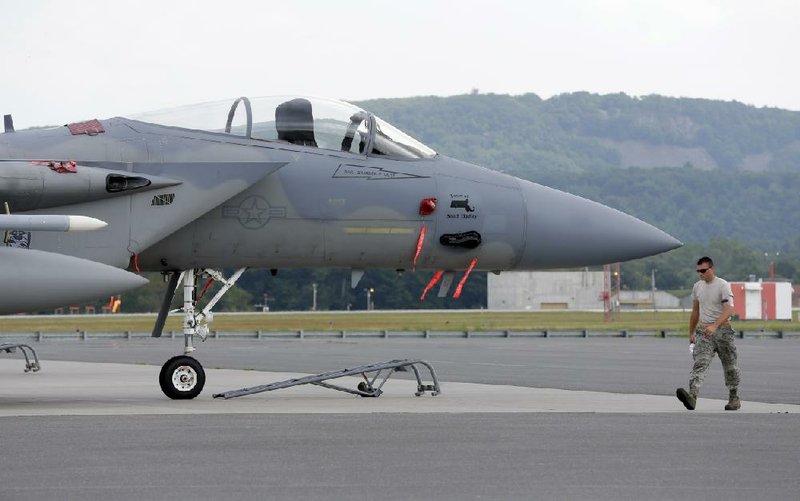 A Massachusetts Air National Guard airman walks past an F-15C fighter Wednesday at the Barnes air base in Westfield, Mass. One of the Guard’s jets crashed Wednesday in Virginia.