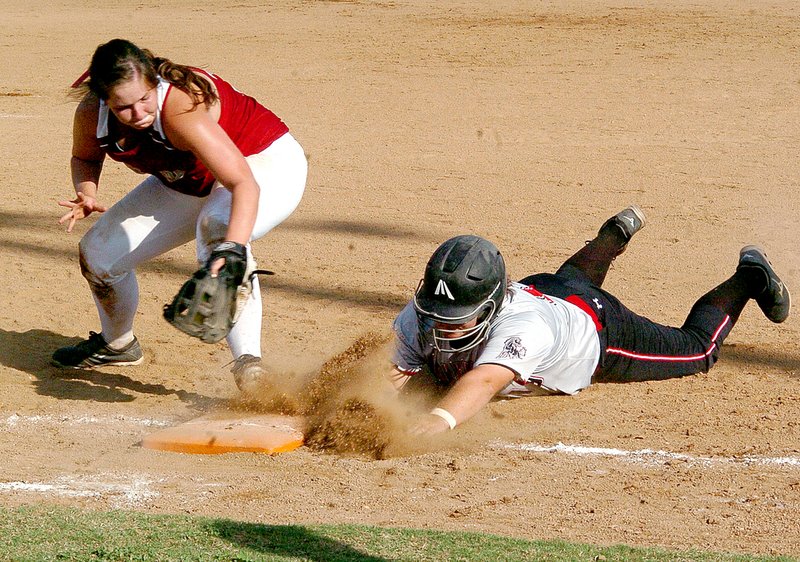 RICK PECK MCDONALD COUNTY PRESS McDonald County&#8217;s Kyla Buchanan dives back to first base to beat a tag during the Lady Mustangs 3-2 win Tuesday over Nevada at McDonald County High School. Buchanan singled and scored the winning run in the Lady Mustangs 3-2 win in extra innings.