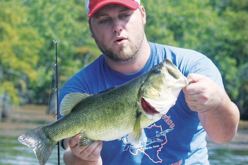 Nathan Sugg of Little Rock gives a big smile after landing a largemouth bass that struck a small spinnerbait. Sugg had been having a slow day before switching from a chunky buzzbait to the little spinner. That move allowed him to catch the biggest bass of his life and about two dozen smaller ones.