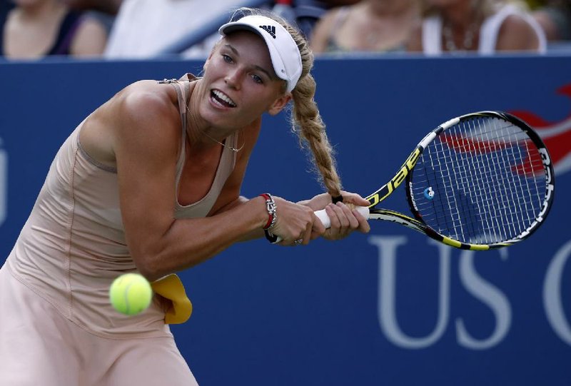 Caroline Wozniacki gets her racket caught in her hair as she tries to return a shot during Wednesday’s second-round match at the U.S. Open against Aliaksandra Sasnovich of Belarus. Wozniacki lost the point but won the match.