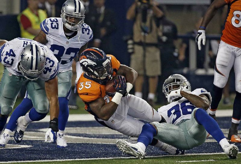 Denver Broncos running back Kapri Bibbs (35) fights past Dallas Cowboys defenders Ahmad Dixon (36) and Ryan Smith (33) into the end zone for a touchdown in the second half of Thrusday’s exhibition game in Arlington, Texas. Denver won 27-3.