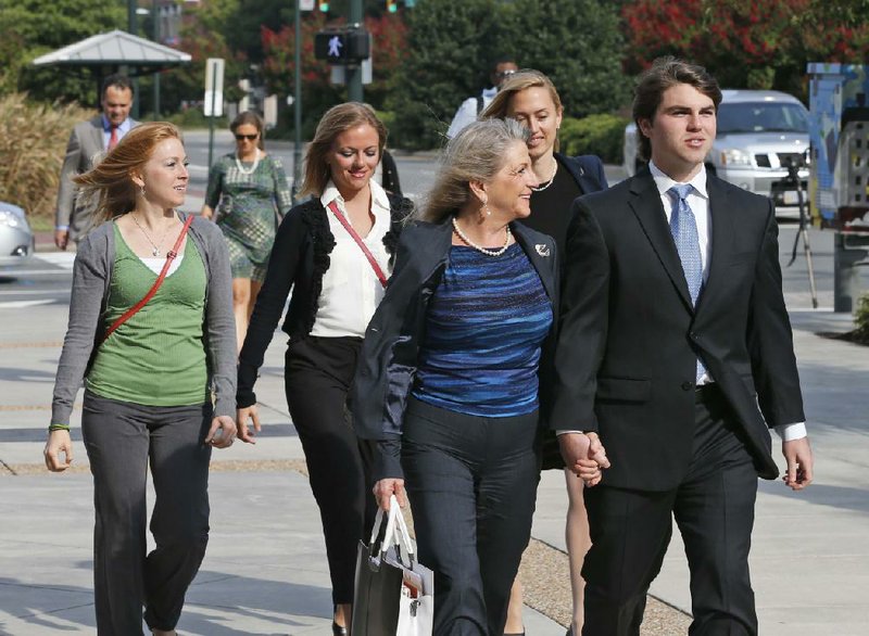 Former Virginia first lady, Maureen McDonnell, front left, holds hands with her son, Bobby McDonnell, right as they arrive at Federal Court  followed by daughter Cailin Young, left, Rachel McDonnell, second from right, and attorney Heather Martin, back right, in Richmond, Va., Thursday, Aug. 28, 2014.  The prosecution in the McDonnell corruption case begins it's rebuttal today. (AP Photo/Steve Helber)