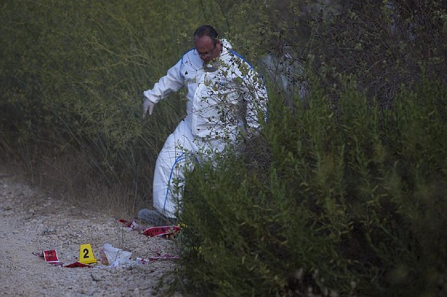 Israeli police forensic experts work at the scene where a body was found Thursday in a Jerusalem forest.