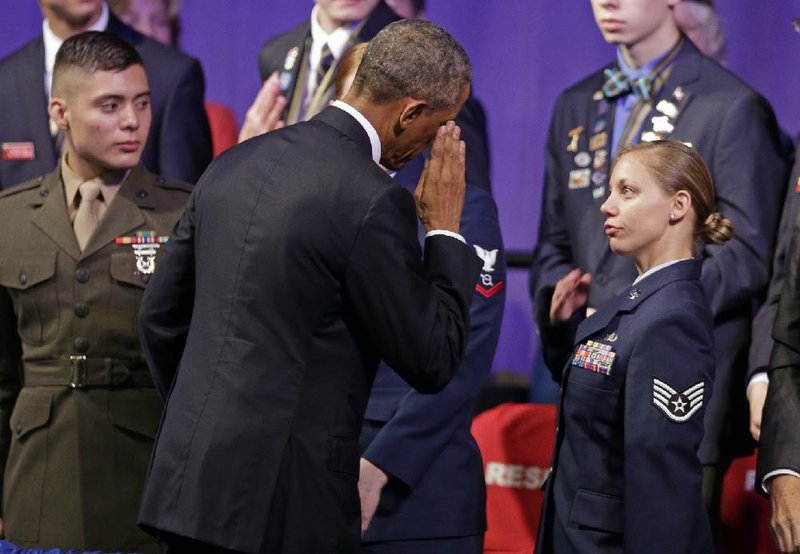 President Barack Obama salutes an airman after speaking at the American Legion national convention in Charlotte, N.C., Tuesday, Aug. 26, 2014. Three months after a veterans' health care scandal rocked his administration, President Barack Obama is taking executive action to improve the mental well-being of veterans. The president was to announce his initiatives during an appearance before the American Legion National Convention that is fraught with midterm politics. (AP Photo/Chuck Burton)