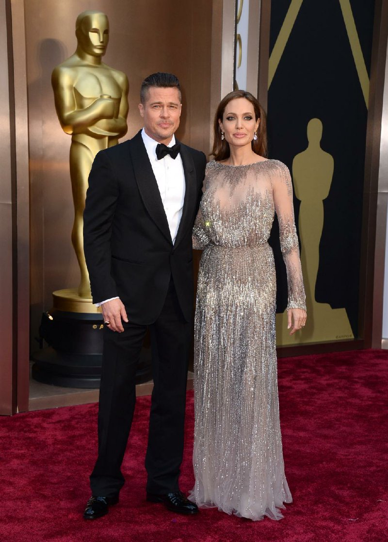 FILE - In this Sunday, March 2, 2014, file photo, Brad Pitt, left, and Angelina Jolie arrive at the Oscars at the Dolby Theatre in Los Angeles. Jolie and Pitt were married Saturday, Aug. 23, 2014, in France, according to a spokesman for the couple. (Photo by Jordan Strauss/Invision/AP, File)