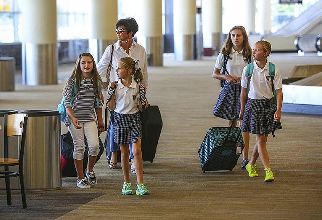 Rhea Middleton escorts her daughters and two friends — Ava Wahlquist (from left), Lauren Middleton, Lindsay Middleton and Lauren Grace Perry — through Bill and Hillary Clinton National Airport/Adams Field in Little Rock on Thursday as they prepare for a Labor Day weekend trip to Chicago.