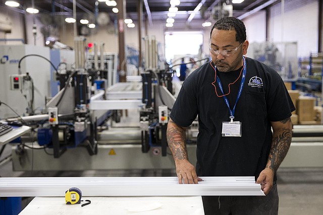 In this Aug. 7, 2014 photo a worker assembles construction supplies at Northeast Building Products in Philadelphia. The Commerce Department issues its second estimate of how fast the U.S. economy grew in the April-June quarter on Thursday, Aug. 28, 2014.