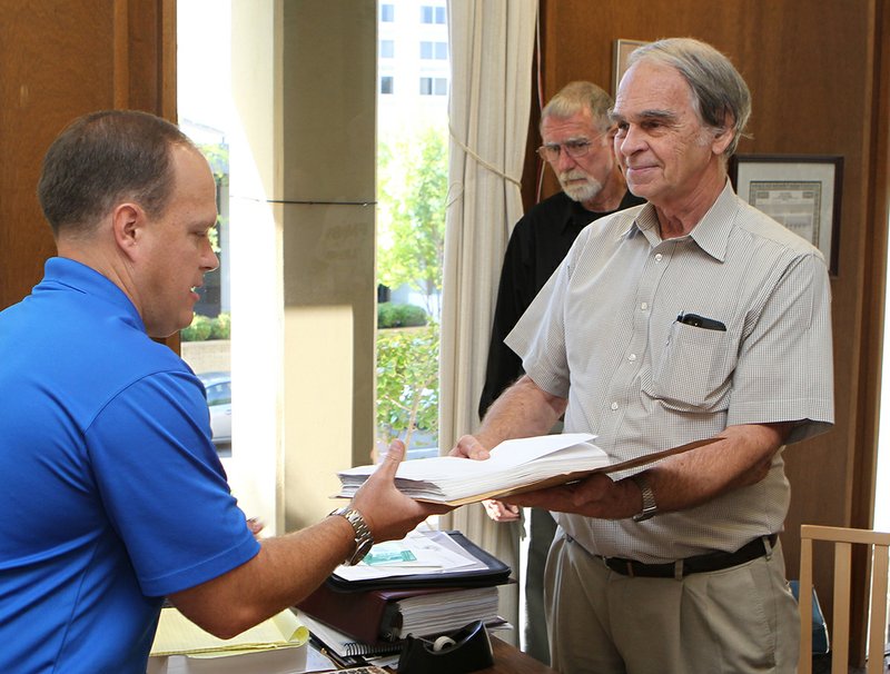 The Sentinel-Record/Richard Rasmussen PETITION PRESENTED: Garland Good Government Group Chairman Bob Driggers, right, presents a petition to City Clerk Lance Spicer Thursday as Don Morphew looks on. The petition seeks to have the DeGray Lake water procurement project placed on the Nov. 4 general election ballot.