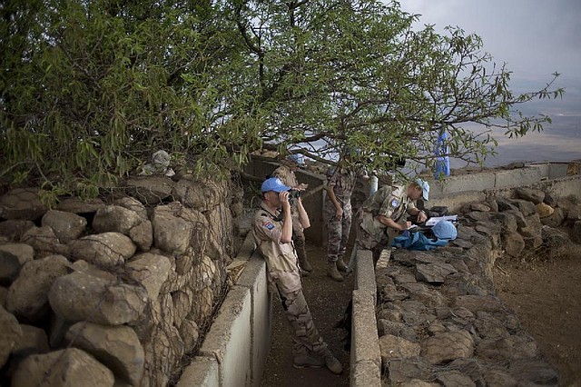 U.N. peacekeepers keep an eye on Syria’s Quneitra province Friday at an observation point on Mount Bental in the Israeli-controlled Golan Heights overlooking the border with Syria.