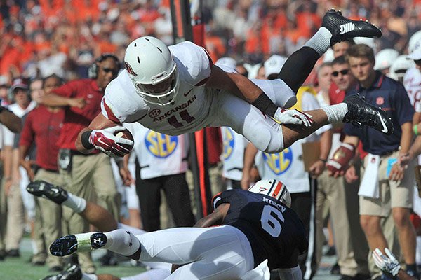 Arkansas tight end AJ Derby gets knocked out of bounds by Auburn's Jonathon Mincy in the second quarter of a game on Saturday, Aug. 30, 2014 at Jordan-Hare Stadium in Auburn, Ala.