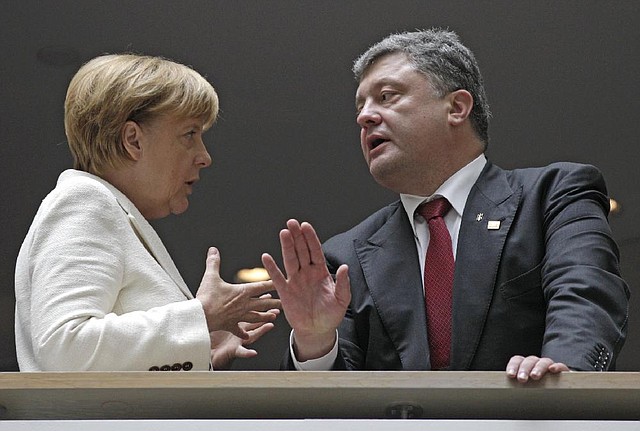 Ukrainian President Petro Poroshenko talks Saturday with German Chancellor Angela Merkel during a European People’s Party meeting before the European Union summit in Brussels.