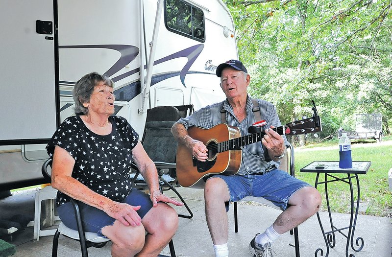 STAFF PHOTO FLIP PUTTHOFF Pat, left, and Gene Hamm sing a country song Aug. 22 at their campsite at Horseshoe Bend park on Beaver Lake. The Hamms have been park attendants since 1979 and have been at Horseshoe Bend since 1992. They&#8217;ll retire from the job in mid-September.