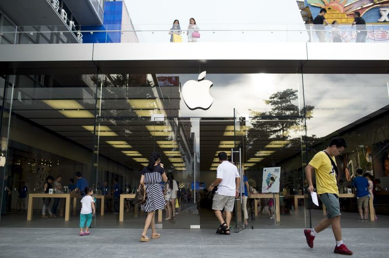 Customers enter an Apple Inc. store in the Nanshan district of Shenzhen, China, on Wednesday, Aug. 6, 2014. Apple products were left off a Chinese government procurement list after the company failed to submit documents that included a pledge not to violate state or public interests, according to government officials familiar with the process. Photographer: Brent Lewin/Bloomberg