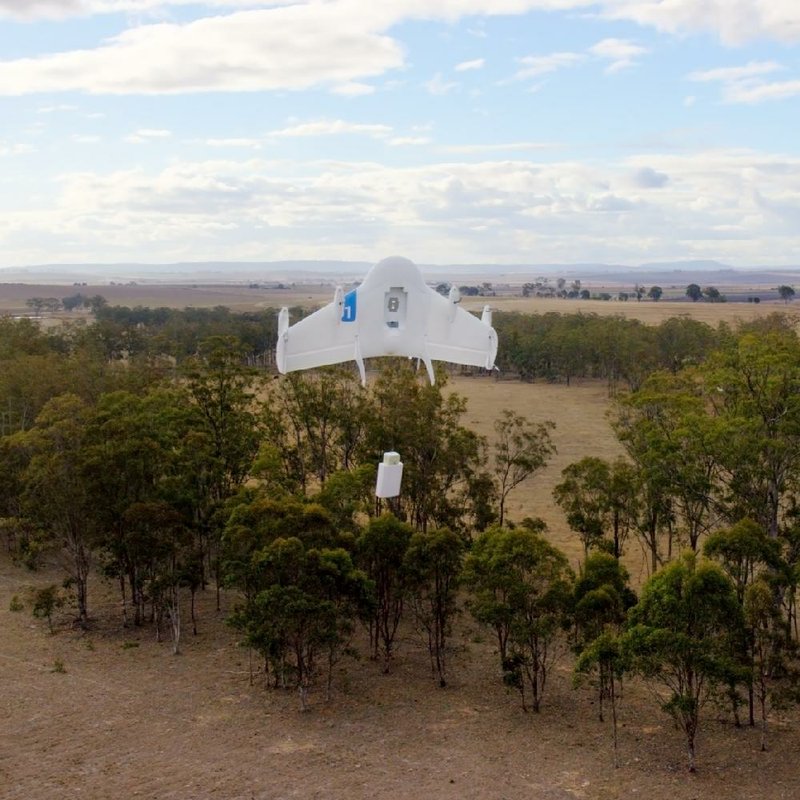 A "Project Wing" drone, developed by Google Inc.'s X laboratory division, drops a parcel as it flies over a farm in Queensland, Australia, in this undated handout photo released to the media on Friday, Aug. 29, 1014. Google's X laboratory division is developing drones that can handle deliveries, a move that would be in direct competition with the e-commerce company that is testing its own shipment service using self-flying machines. Source: Google Inc. via Bloomberg EDITOR'S NOTE: NO SALES. EDITORIAL USE ONLY.