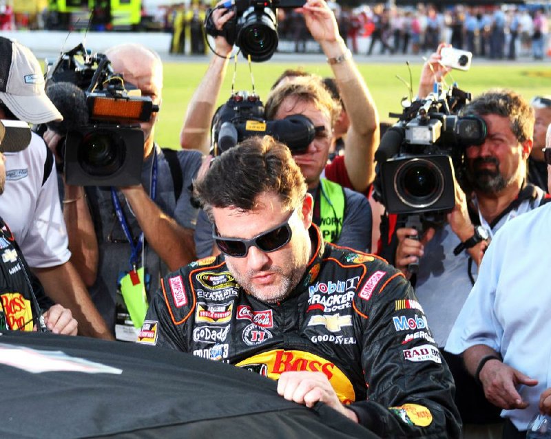 Tony Stewart climbs into his car to start a NASCAR Sprint Cup auto race at Atlanta Motor Speedway, Sunday, Aug. 31, 2014, in Hampton, Ga. In his first event since his sprint car struck and killed a fellow driver, Stewart slammed the wall twice and settled for a dismal 41st-place finish at Atlanta Motor Speedway on Sunday, leaving him in a must-win situation next weekend at Richmond to make NASCAR's Chase for the Sprint Cup championship. (AP Photo/Dale Davis)