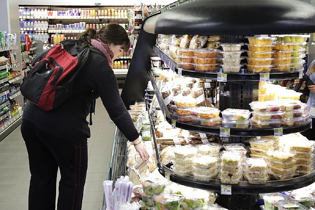 In this Wednesday, May 15, 2013, photo, a customer shops for a sandwich in the fresh food section at the Walgreens flagship store in the Empire State Building, in New York .The nationís major drugstore chains are opening more in-store clinics in response to the massive U.S. health care overhaul, which is expected to add about 25 million newly insured people who will need medical care and prescriptions, as well as  offering more services as a way to boost revenue in the face of competition from stores like Safeway and Wal-Mart.  (AP Photo/Mark Lennihan)