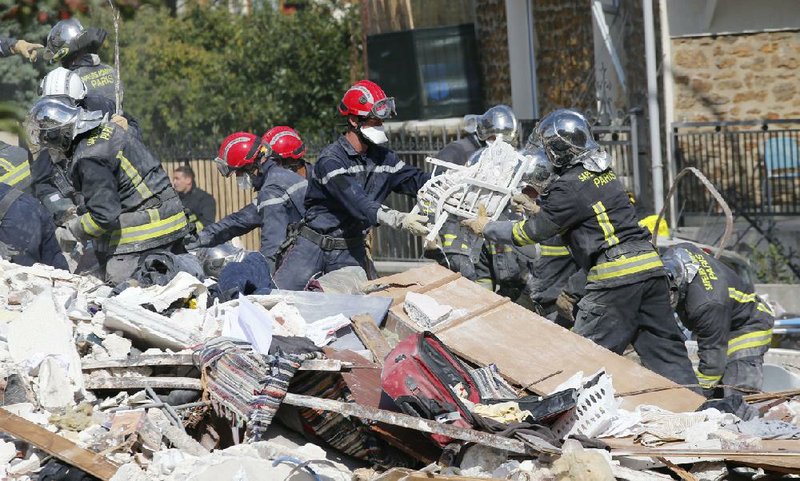 French firemen search in the rubble of a building after an explosion collapsed it, in Rosny-sous-Bois, outside Paris, Sunday, Aug. 31, 2014. French authorities say a four-story building in a northeastern Paris suburb has collapsed after an explosion, killing a child. More people are thought to underneath the rubble. Speaking on i-Tele, fire department spokesman Gabriel Plus said around 10 people were evacuated from the building in Rosny-sous-bois that occurred early Sunday morning. Plus said that around another 10 people could still be underneath the rubble, and emergency teams were working hard to rescue people who might be trapped. "We could still find living victims in the hours to come," he said. Interior Minister Bernard Cazeneuve has arrived at the scene, but couldn't confirm a theory that the explosion was caused by a gas leak. (AP Photo/Christophe Ena)

