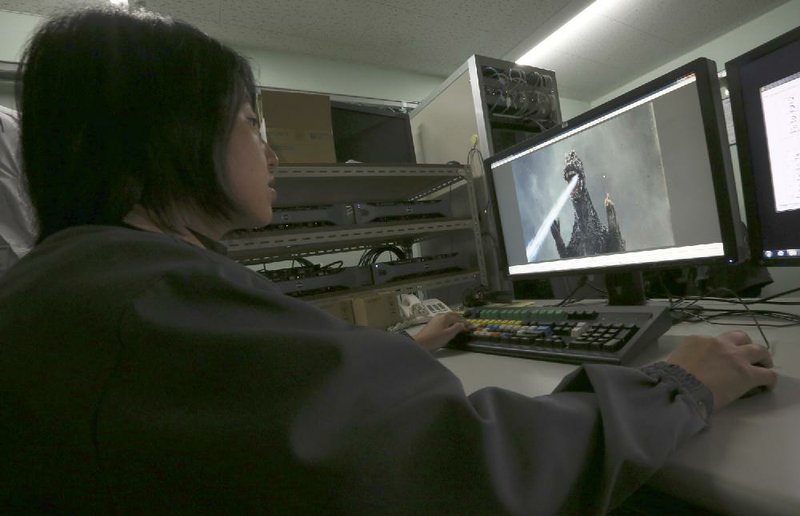 A film process technician checks the digitalized film of a Godzilla movie at Tokyo Laboratory Ltd. in Tokyo, Wednesday, Aug. 27, 2014. At the humble Tokyo laboratory, Godzilla, including the 1954 black-and-white original, is stomping back with a digital makeover that delivers four times the image quality of high definition. Experts say the chemical reactions used to make old movies stored far greater detail than was visible with the limited projection technology of the era, as well as with subsequent digital updates. (AP Photo/Eugene Hoshiko)