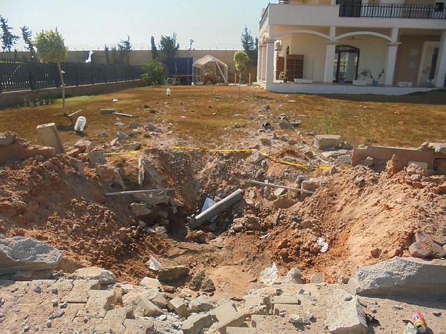 In this photo taken during a tour offered to onlookers and journalists by the Dawn of Libya militia on Sunday, Aug. 31, 2014, damage is seen in the front yard of a building at the U.S. Embassy compound in Tripoli, Libya, after weeks of violence between rival militias over control of the capital. The Islamist-allied militia group in control of Libya's capital now guards the U.S. Embassy and its residential compound, a commander said Sunday, as onlookers and journalists toured the abandoned homes of diplomats who fled the country more than a month ago. (AP Photo)