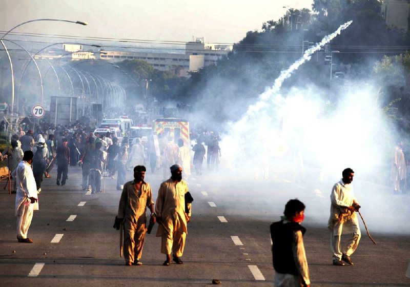 Police use tear gas to disperse protesters in Islamabad, Pakistan, Monday, Sept. 1, 2014. Anti-government protesters stormed Pakistan’s state television building Monday, forcing the channel briefly off the air as they clashed with police and pushed closer to the prime minister’s residence. (AP Photo/Anjum Naveed)