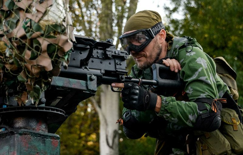 A Pro-Russian rebel prepares arms for the the assault on the positions of Ukrainian army in Donetsk airport, eastern Ukraine, Sunday, Aug. 31, 2014. Russian President Vladimir Putin on Sunday called on Ukraine to immediately start talks on a political solution to the crisis in eastern Ukraine. Hours later, Ukraine said a border guard vessel operating in the Azov Sea was attacked by land-based forces. (AP Photo/Mstislav Chernov)