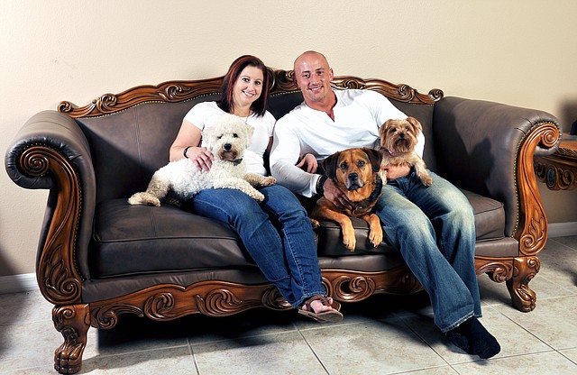 Kris Rotonda, founder of YouMustLoveDogsDating.com, poses with his girlfriend, Denise Fernandez, and three of his four dogs: Kobe, a bichon frise; Jordan, a bull mastiff German shepherd and Samoyed mix; and Coco, a Yorkie