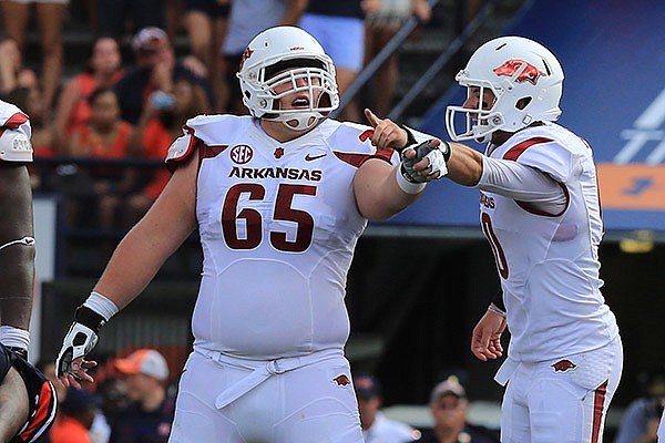 Arkansas center Mitch Smothers (65) and quarterback Brandon Allen point out instructions prior to a play Saturday, Aug. 30, 2014 at Jordan-Hare Stadium in Auburn, Ala.