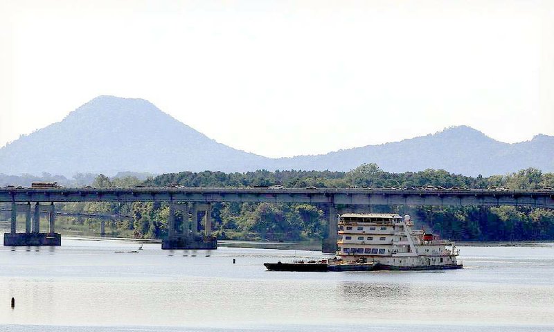 Pinnacle Mountain looms behind the Interstate 430 bridge over the Arkansas River as the MV Mississippi enters the lock at Murray Lock and Dam.