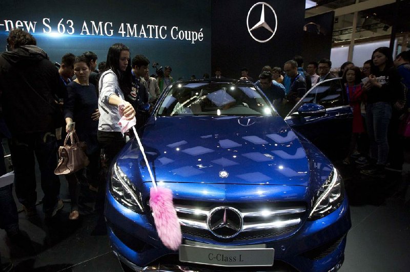 A staff member cleans a Mercedes at the company booth at the Auto China show in Beijing in April. A report released Tuesday said officials at foreign companies in China feel they are being treated unfairly by the government.